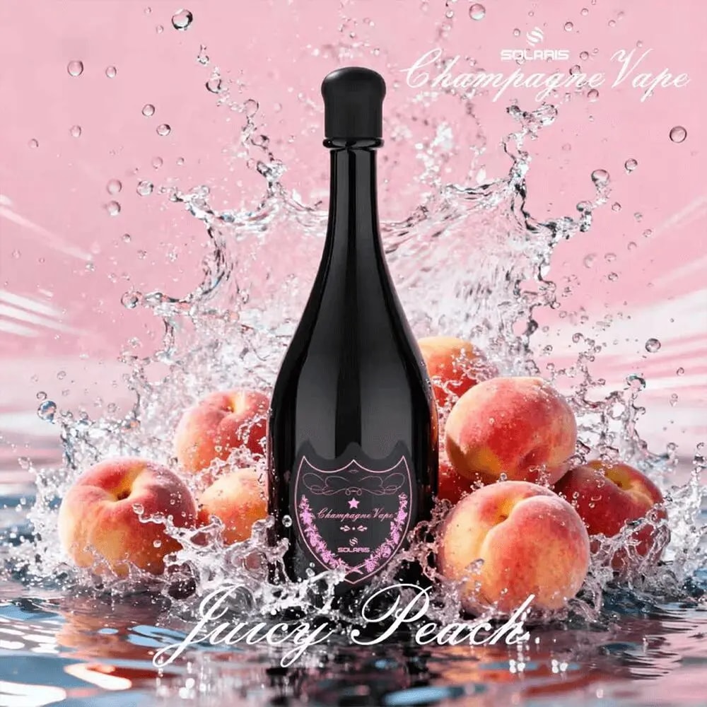 En mörk champagneflaska centrerad bland persikor och en skvätt vatten på en rosa bakgrund; etiketten visar en lila-rosa design med orden Juicy Peach.