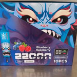 Box of disposable vape devices featuring a fierce blue creature, labeled "Blueberry Raspberry 22000 Puffs, 850mAh, 10PCS."